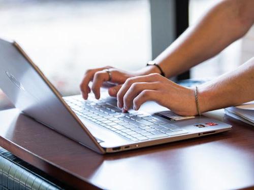 Student types on a laptop.